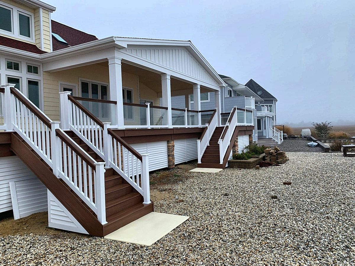 Raised deck with white railings, glass panels and composite stairs
