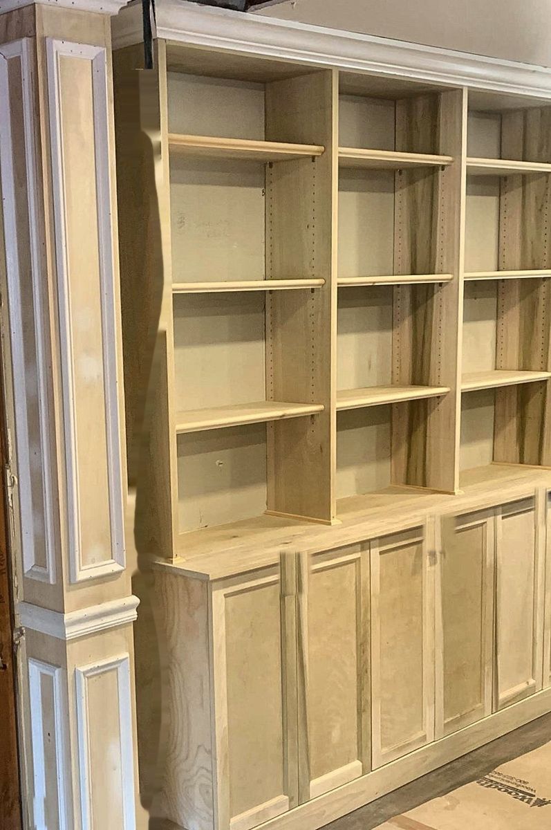 Built-in bookcases and cabinets with a paneled column, before paint
